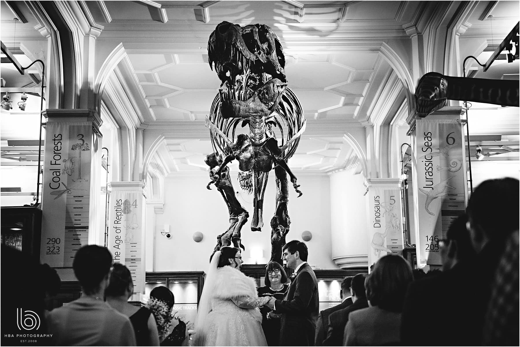 the bride & groom getting married under the T-Rex