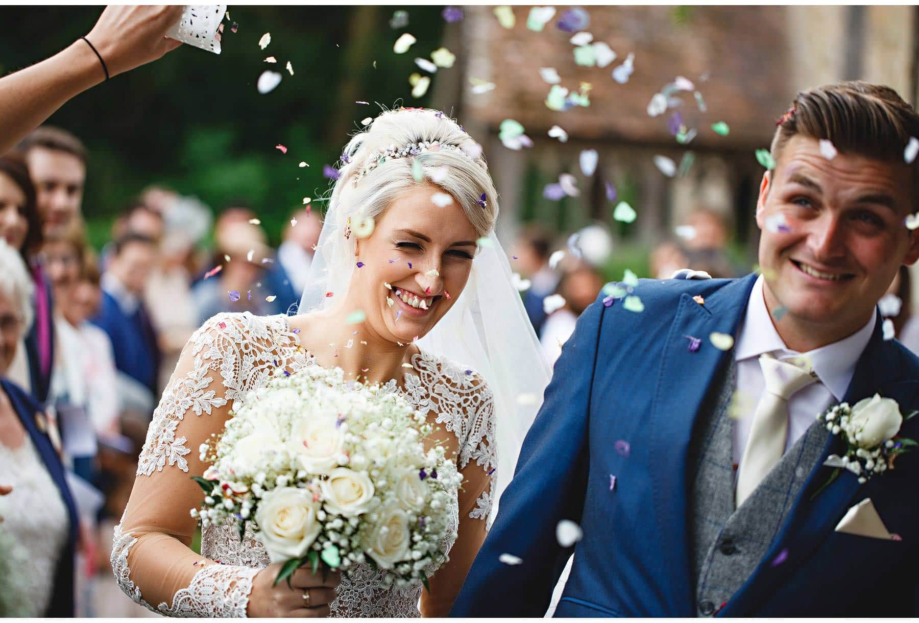 The bride & groom getting covered in confetti