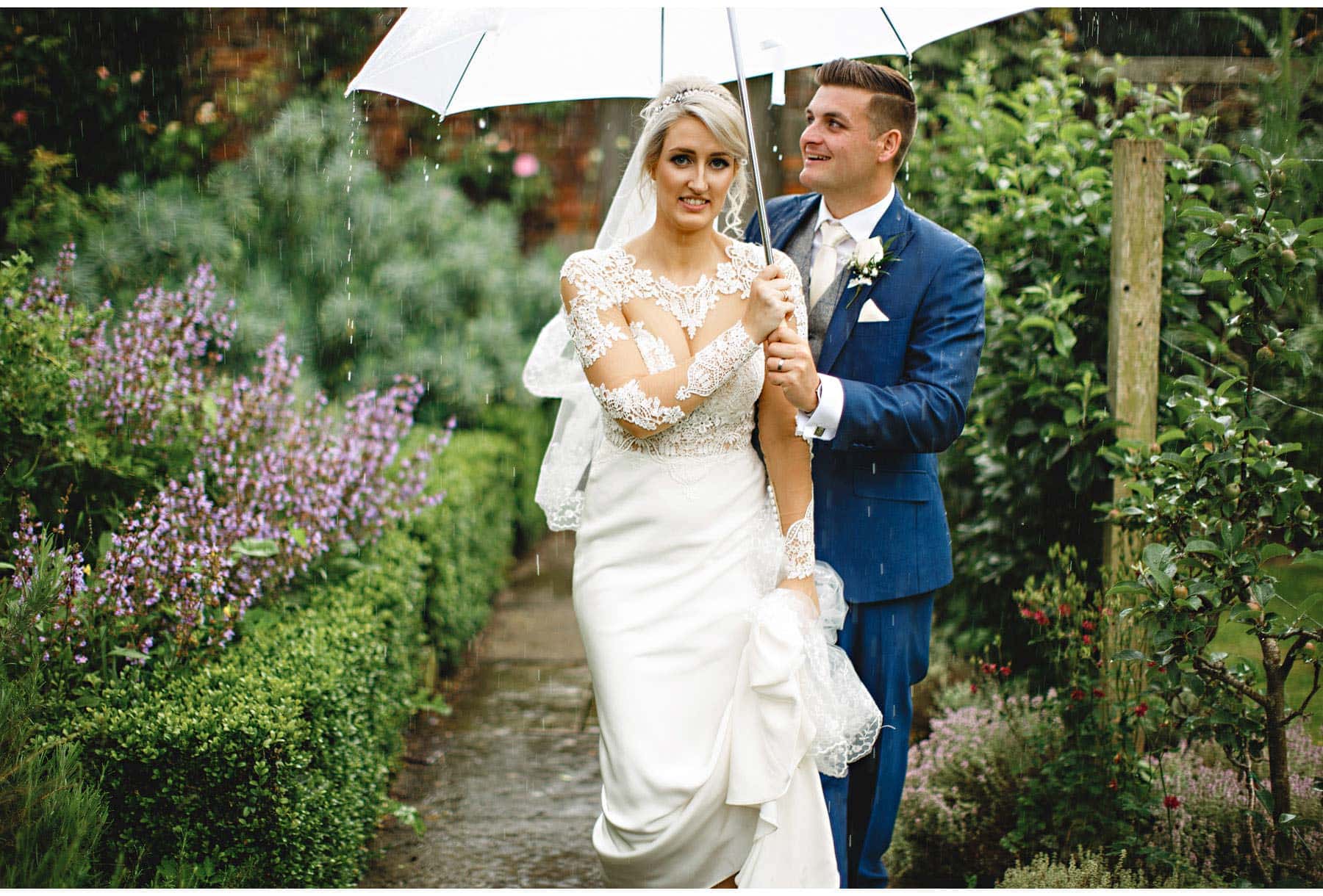 the bride and groom walking in the rain
