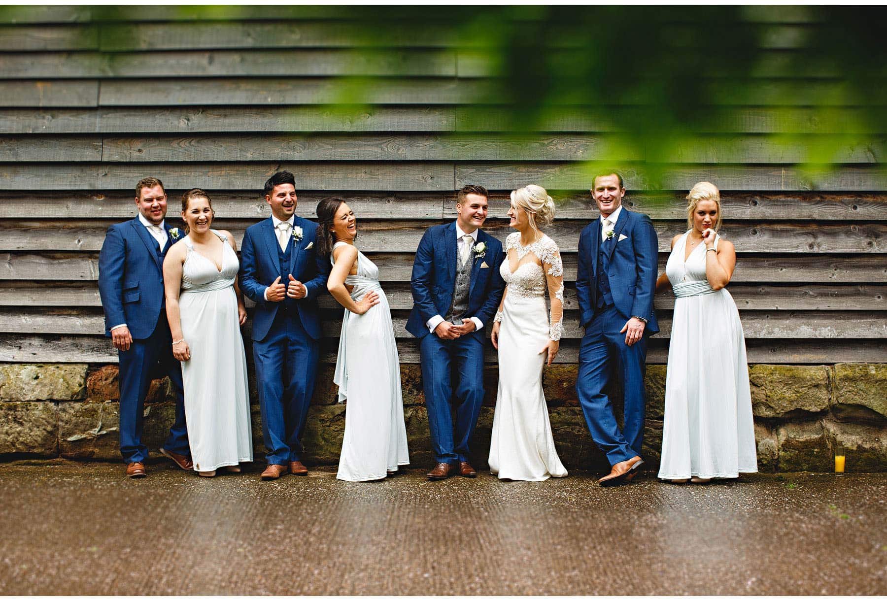 The bridal party leaning against the barn
