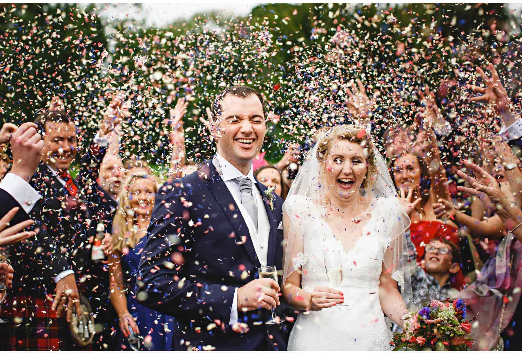The bride & groom getting covered in confetti