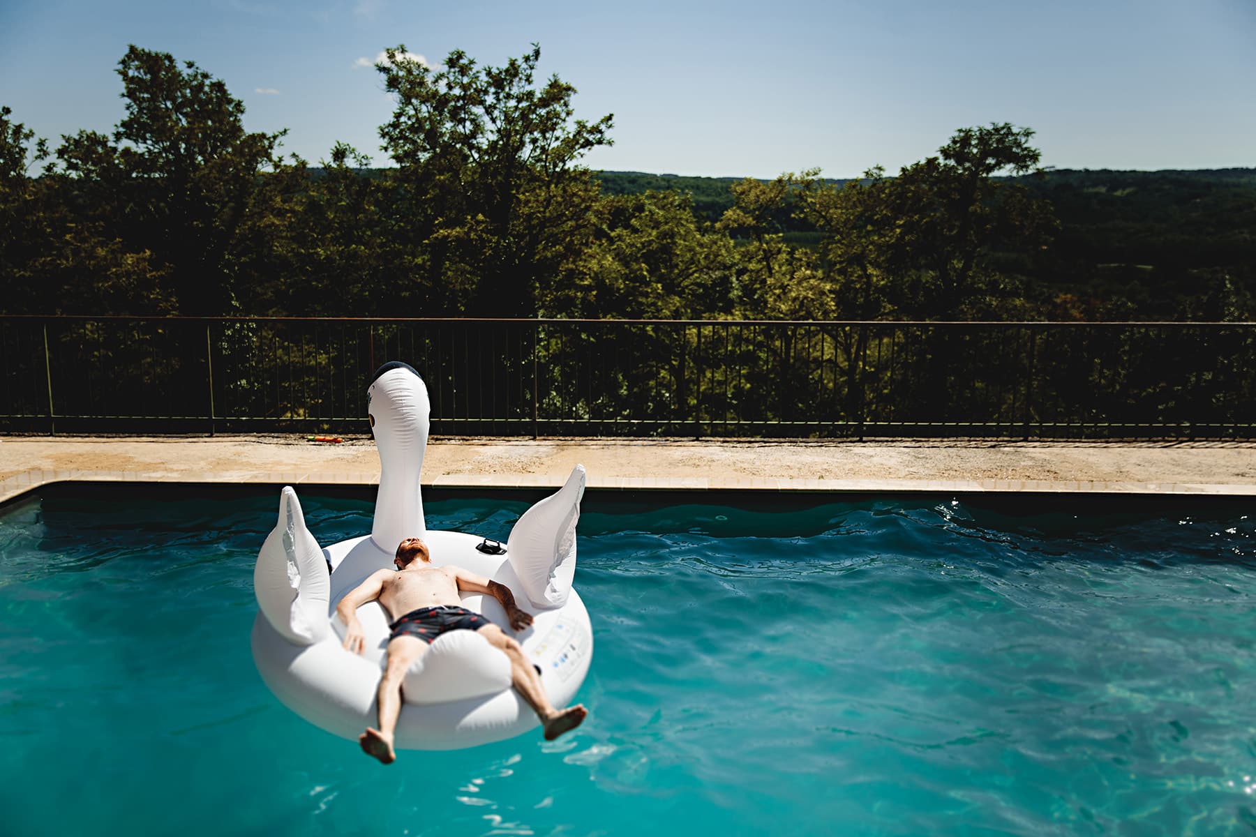 the groom sat in the blue swimmingpool in France at the Chateau Cazenec
