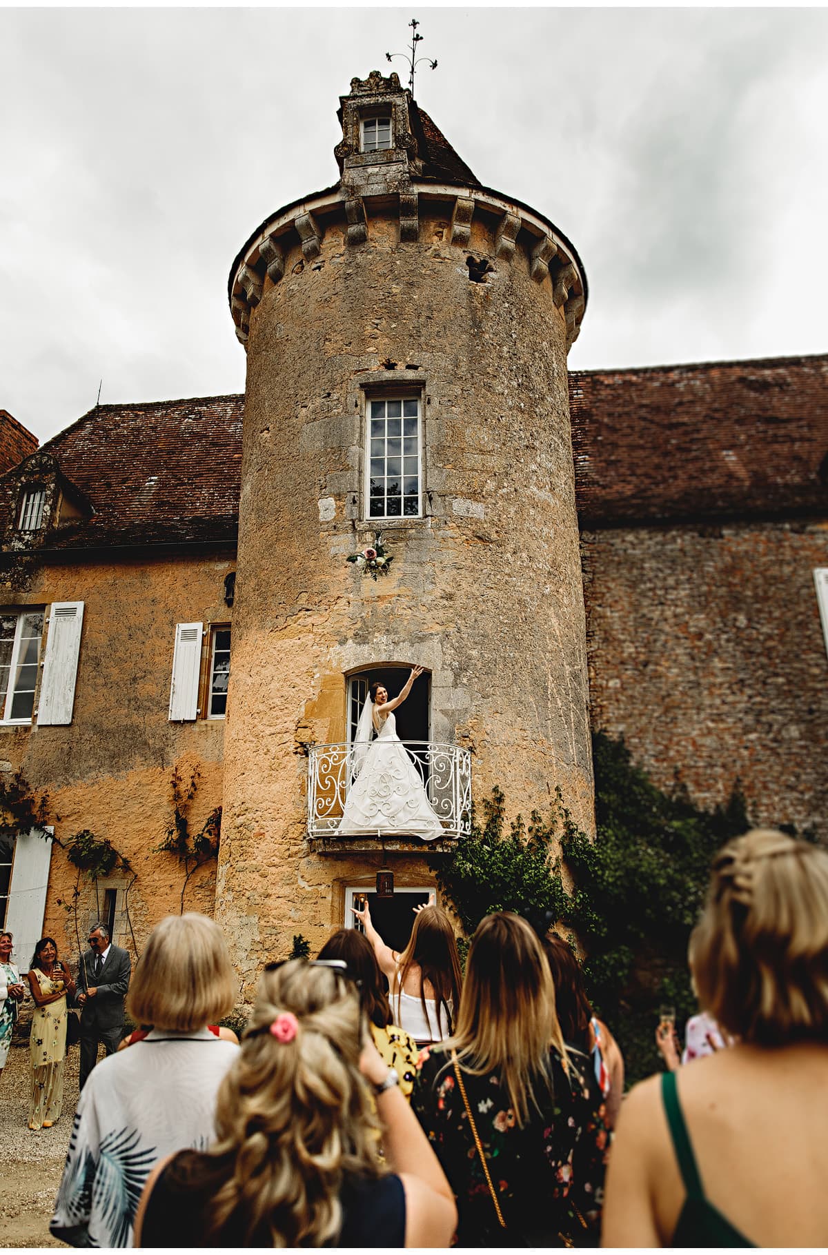 the bride tossing her bouquet from the balcony