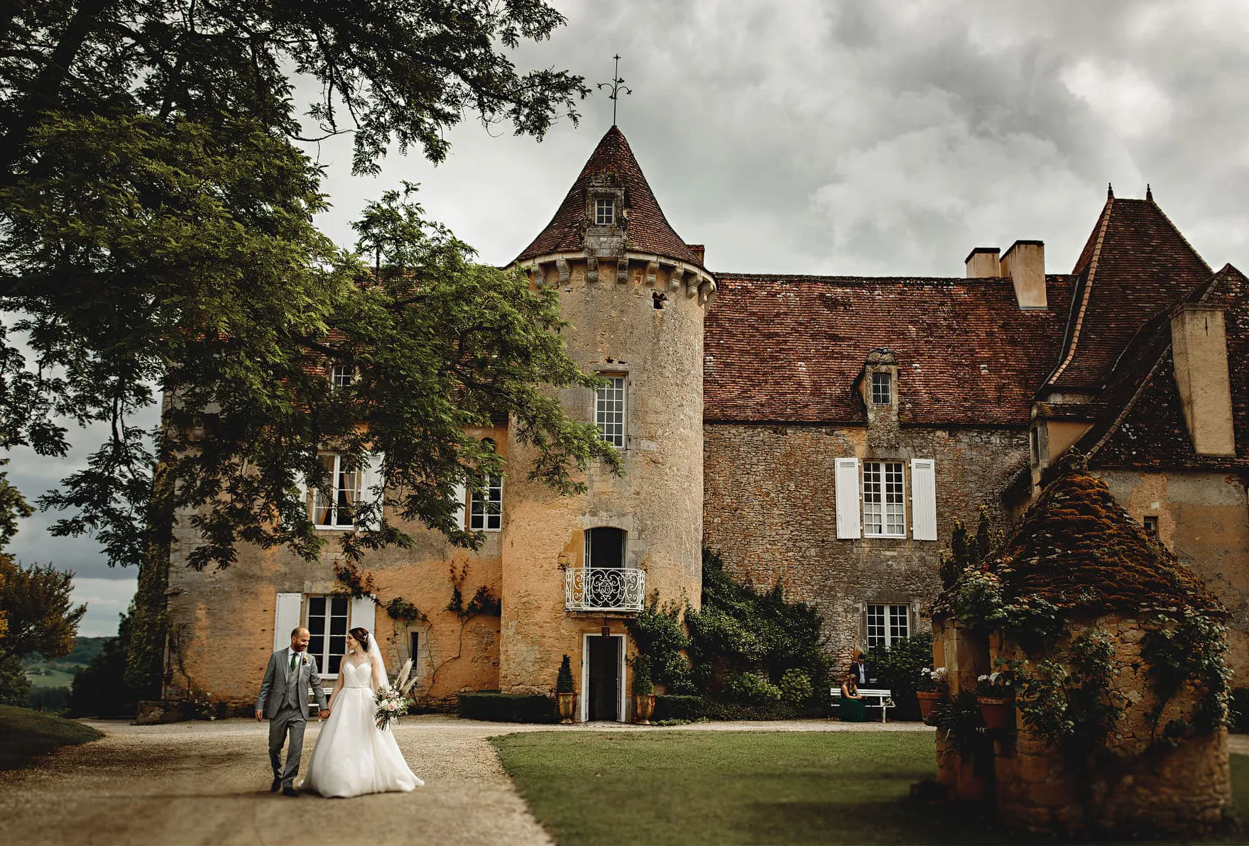 Bride and groom walking away from Château Cazenac in the south of france on their wedding day